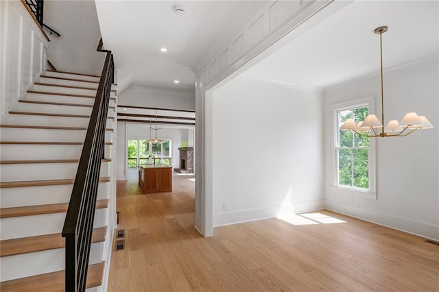 entrance foyer with a chandelier, plenty of natural light, stairway, light wood finished floors, and recessed lighting