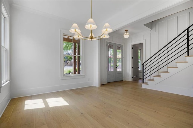entryway with a chandelier, stairs, light wood-style flooring, baseboards, and french doors