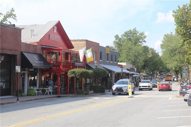 view of asphalt street featuring sidewalks, curbs, and street lights