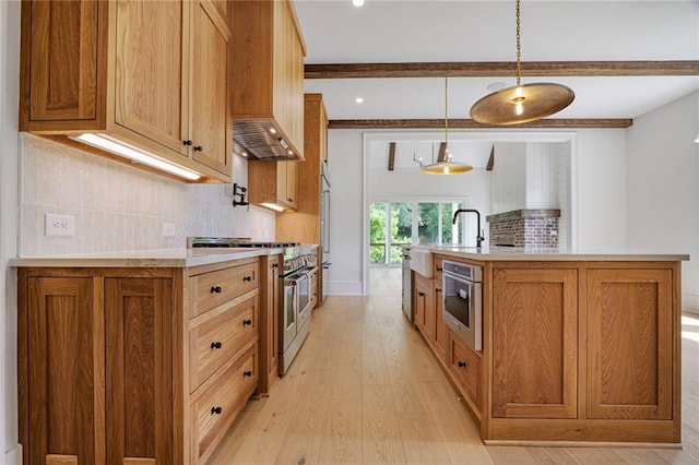 kitchen featuring high quality appliances, light wood-type flooring, a sink, beamed ceiling, and light countertops