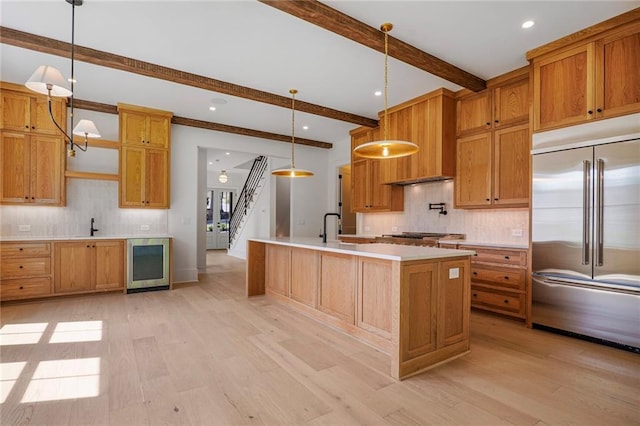 kitchen featuring stainless steel built in fridge, wine cooler, beam ceiling, backsplash, and light countertops