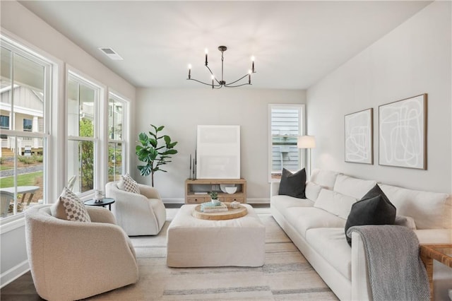 living area with baseboards, visible vents, and an inviting chandelier