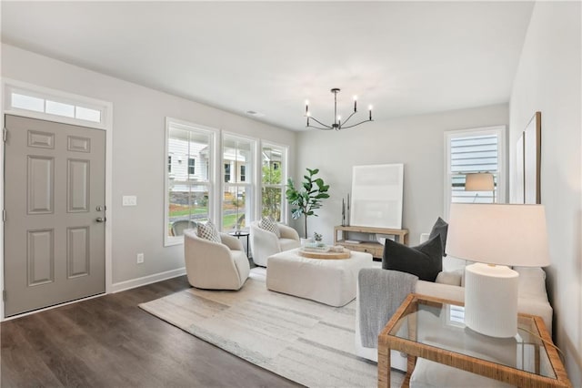 living area with a chandelier, dark wood finished floors, and baseboards