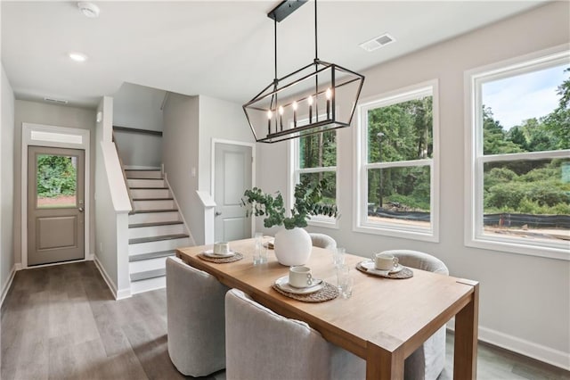 dining area with a wealth of natural light, stairway, wood finished floors, and visible vents