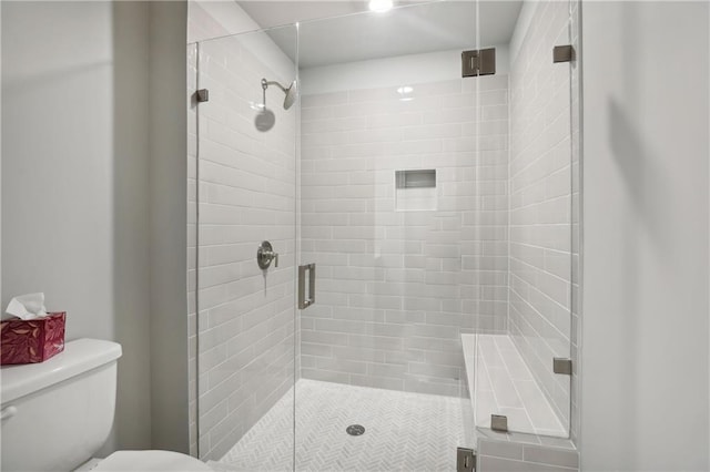 bathroom with a shower stall and toilet