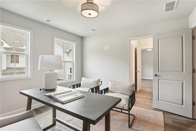 office featuring visible vents, baseboards, and wood finished floors