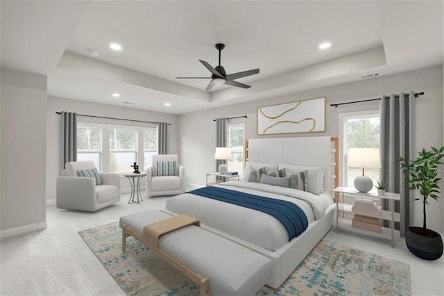 carpeted bedroom featuring a raised ceiling, ceiling fan, and multiple windows