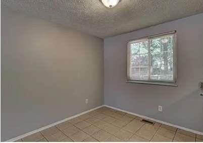 unfurnished room with a textured ceiling