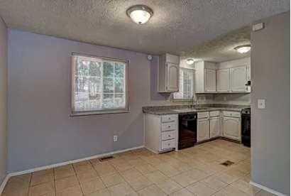 kitchen with range, black dishwasher, a textured ceiling, and white cabinets