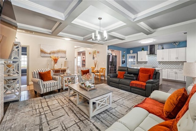 living room featuring beam ceiling, wood finished floors, coffered ceiling, and a chandelier