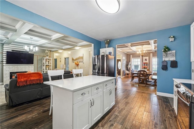 kitchen featuring dark wood-type flooring, an inviting chandelier, appliances with stainless steel finishes, and coffered ceiling