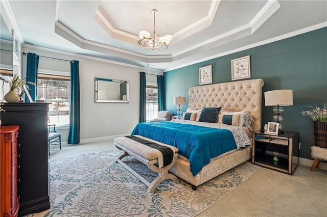 carpeted bedroom with a tray ceiling, a notable chandelier, multiple windows, and baseboards