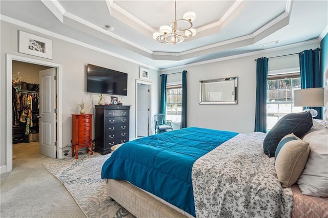 carpeted bedroom featuring visible vents, a walk in closet, crown molding, a raised ceiling, and a chandelier