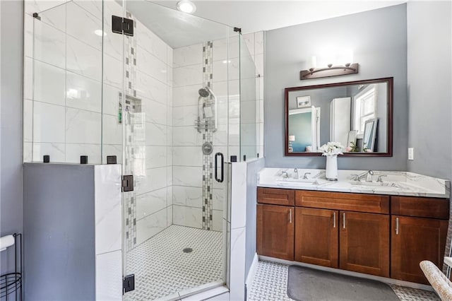 bathroom with a sink, a stall shower, and double vanity