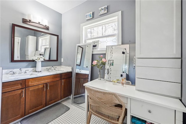 bathroom featuring a sink, a stall shower, and double vanity