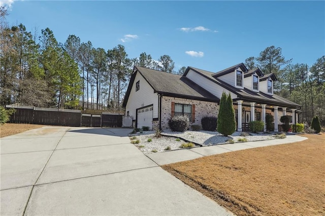 view of home's exterior featuring concrete driveway, fence, and a garage