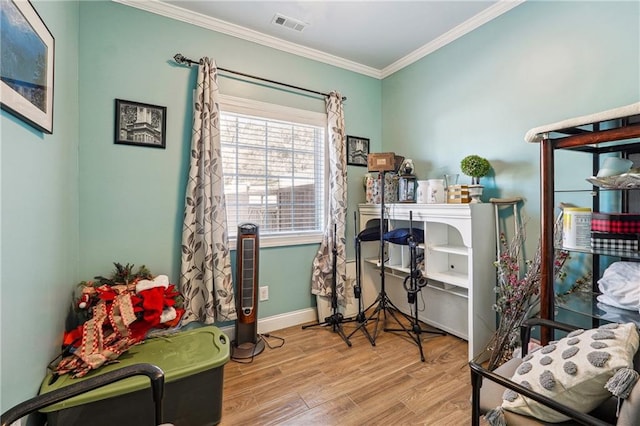 interior space with visible vents, baseboards, wood finished floors, and ornamental molding