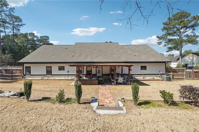 rear view of property with central air condition unit, a patio area, fence, and roof with shingles