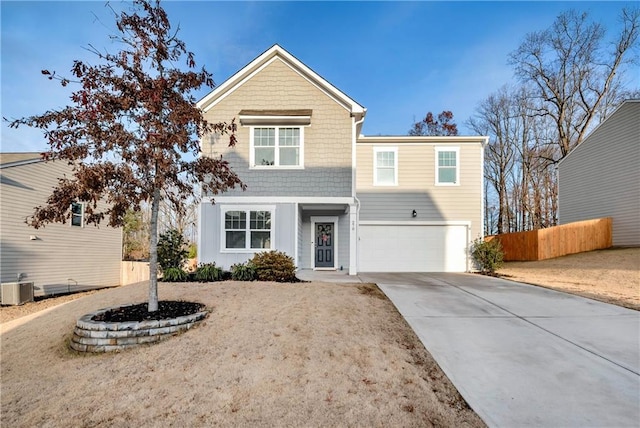 view of front of home featuring a garage, driveway, central AC, and fence