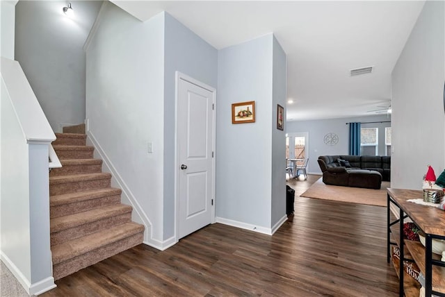 interior space with visible vents, baseboards, dark wood-style floors, and stairs