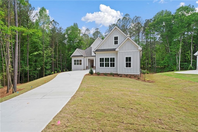 modern inspired farmhouse featuring a front lawn, board and batten siding, and driveway