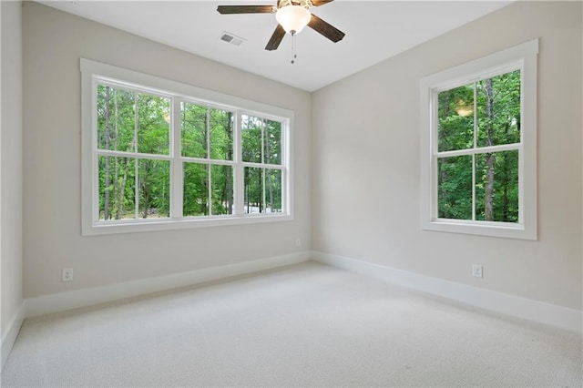 unfurnished room with visible vents, baseboards, ceiling fan, and carpet flooring