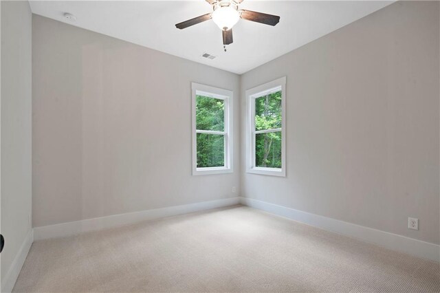 unfurnished room with light colored carpet, visible vents, and baseboards