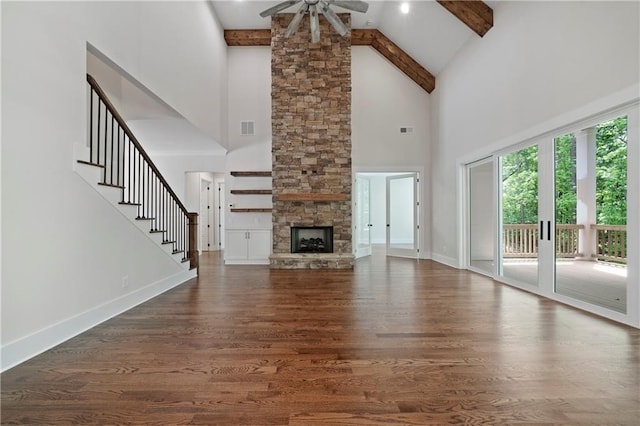 unfurnished living room with visible vents, beam ceiling, dark wood-style floors, baseboards, and stairs