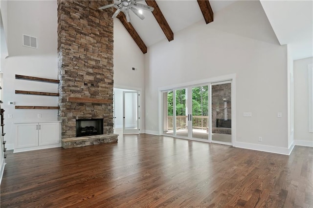 unfurnished living room featuring dark wood-style floors, visible vents, baseboards, beam ceiling, and a fireplace