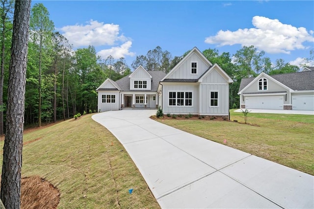 modern farmhouse style home with a front yard, concrete driveway, and board and batten siding