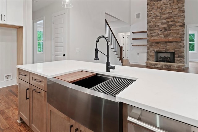 kitchen featuring a sink, visible vents, dark wood-style floors, and light countertops