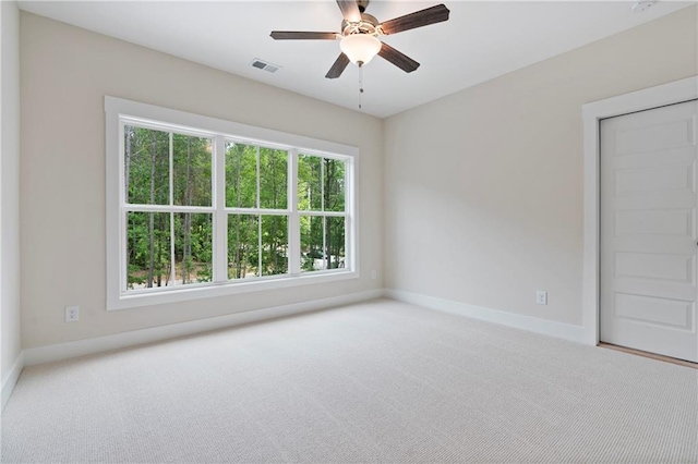 spare room featuring visible vents, a ceiling fan, baseboards, and carpet floors