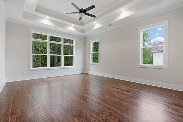 unfurnished room featuring dark wood finished floors, a tray ceiling, recessed lighting, and baseboards