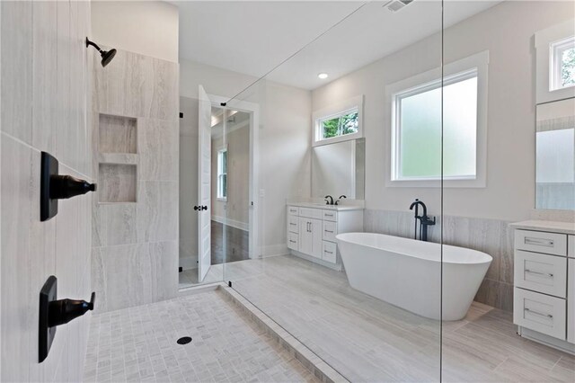 full bathroom with vanity, tile patterned floors, a freestanding tub, and a walk in shower