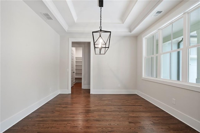 unfurnished dining area featuring visible vents, dark wood-type flooring, a notable chandelier, a tray ceiling, and baseboards