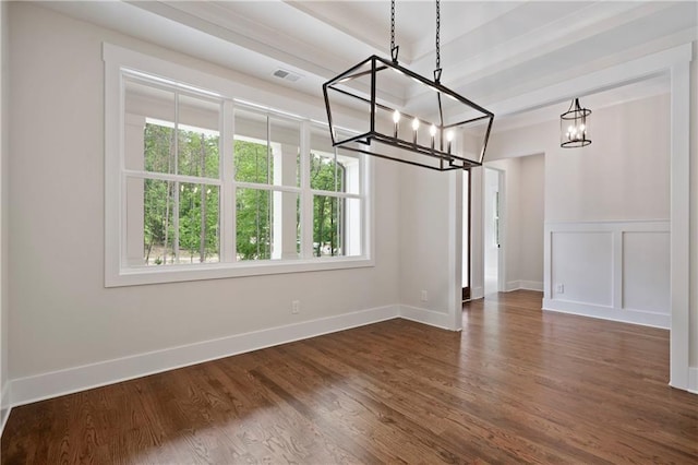 unfurnished dining area with dark wood-style floors, visible vents, a decorative wall, and baseboards