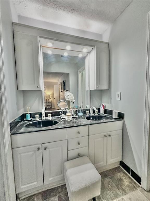 kitchen with white cabinetry, sink, and a textured ceiling