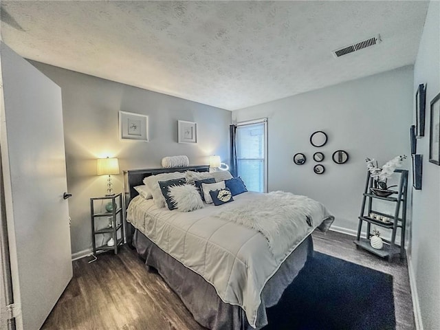 4359 Idlewood Ln, Tucker, GA 30084 - bedroom featuring a textured ceiling, visible vents, baseboards, and dark wood-style flooring