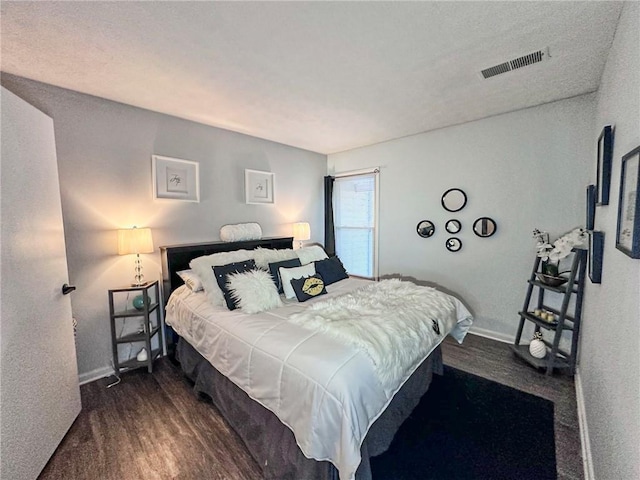 bedroom with dark wood-type flooring