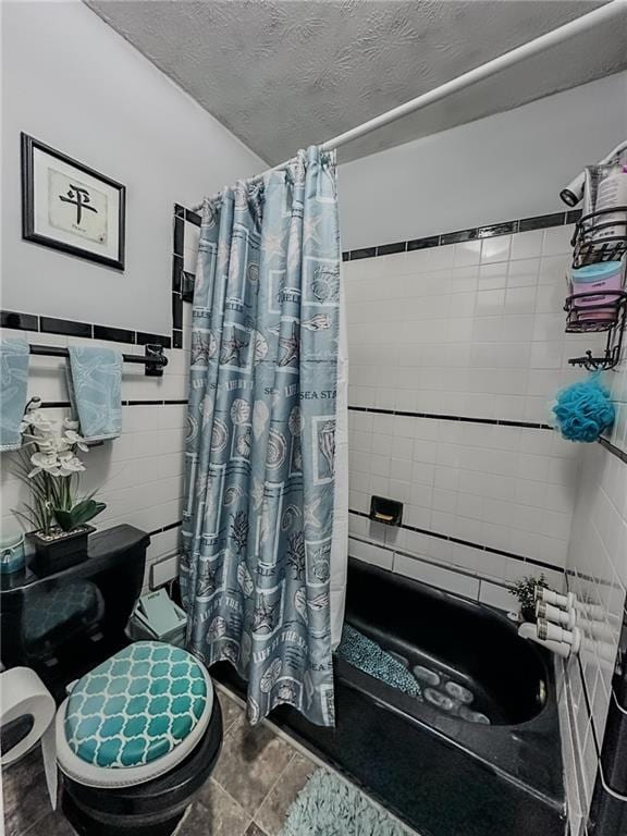 bathroom featuring toilet, a textured ceiling, shower / bathtub combination with curtain, and tile walls