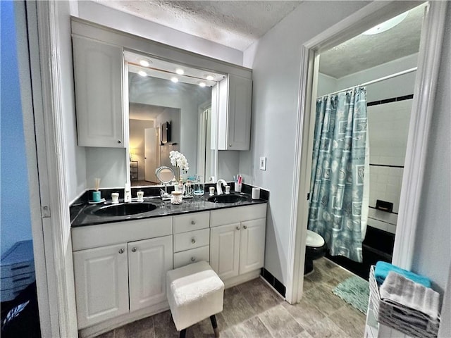 full bathroom with a textured ceiling, toilet, vanity, and shower / bathtub combination with curtain