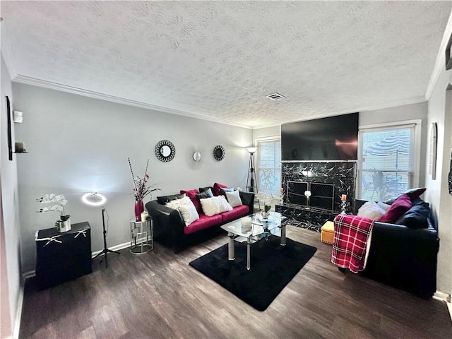 living room with a textured ceiling, dark hardwood / wood-style flooring, crown molding, and a premium fireplace