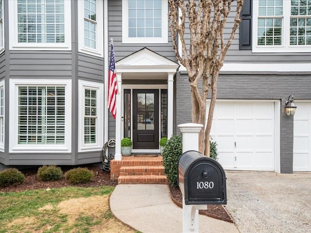 view of exterior entry featuring a garage and driveway