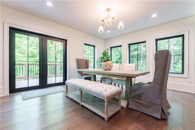 dining space with dark wood-type flooring, a chandelier, and french doors