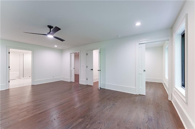 unfurnished bedroom featuring ceiling fan, a closet, ensuite bathroom, and dark hardwood / wood-style flooring