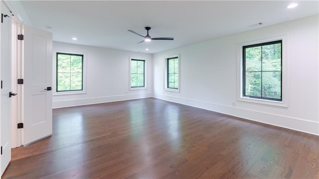 unfurnished room with plenty of natural light, ceiling fan, and dark hardwood / wood-style flooring