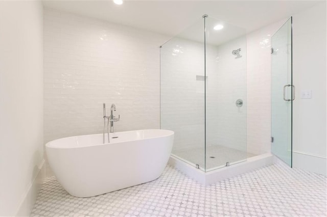 bathroom with tile walls, independent shower and bath, and tile patterned floors