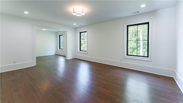 unfurnished room with a wealth of natural light and dark hardwood / wood-style flooring