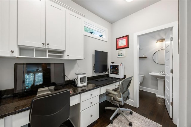office featuring baseboards, built in desk, and dark wood-style floors