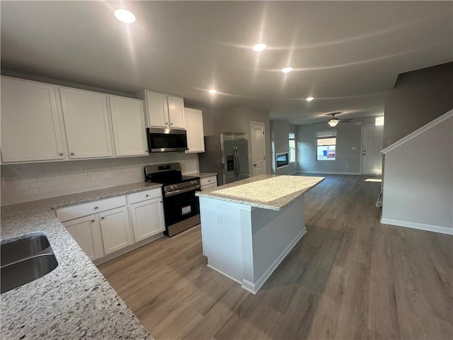 11045 Shadow Creek Ter, Hampton, GA 30228 - kitchen featuring stainless steel appliances, a sink, wood finished floors, a ceiling fan, and white cabinetry